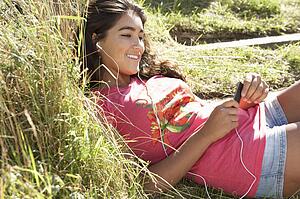 Teenage girl using mp3 player outdoors