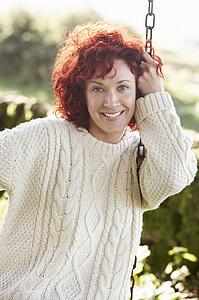 Woman on country garden swing