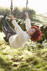 Woman on country garden swing