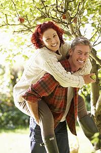 Couple picking apples off tree