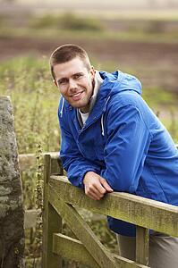 Man leaning on country gate