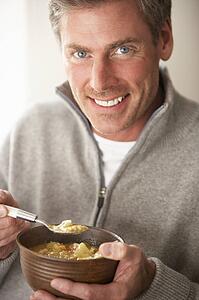 Man eating bowl of soup