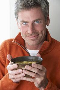 Man holding bowl of soup