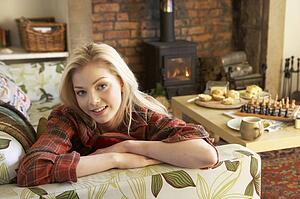 Young woman relaxing by fire