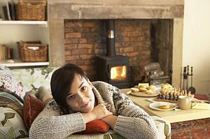 Young woman relaxing by fire