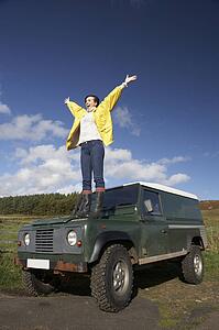 Young woman in countryside with SUV