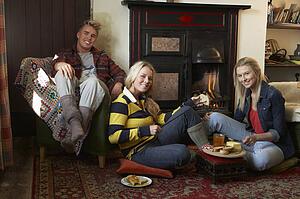 Young adults making toast on open fire