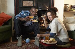 Young couple making toast on open fire