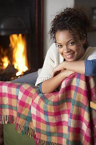 Young woman sitting by open fire