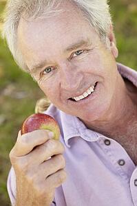 Senior man eating apple