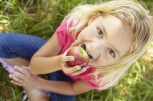 Portrait of happy girl with apple