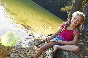 Happy girl fishing at lake