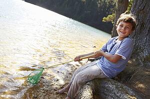 Happy boy fishing at lake