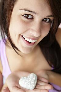 Teenage girl holding silver heart
