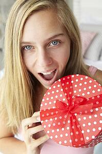 Teenage girl holding gift box