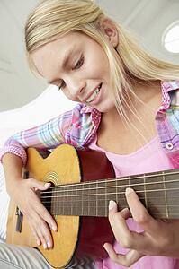 Teenage girl playing acoustic guitar