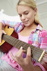 Teenage girl playing acoustic guitar