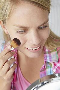 Teenage girl putting on make-up