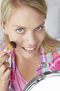 Teenage girl putting on make-up