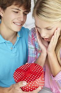 Teenage boy giving gift to girl