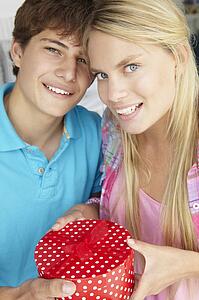 Teenage boy giving gift to girl