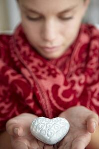 Teenage girl holding silver heart