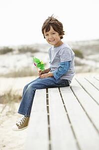 Young boy on beach with windmill
