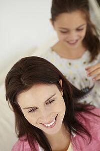 Girl brushing mother's hair