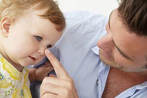 Doting father with baby daughter at home
