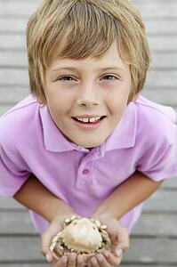 Young boy holding crab