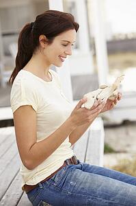 Woman sitting outdoors holding starfish