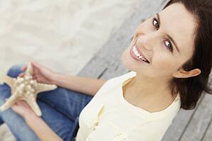 Woman sitting outdoors holding starfish