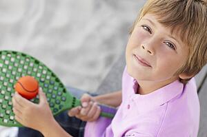 Young boy outdoors with bat and ball