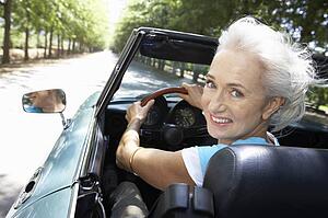 Senior woman in sports car