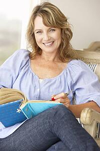 Mid age woman writing in notebook