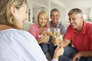 Mid age couples drinking together at home