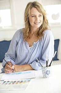 Mid age woman painting with watercolors
