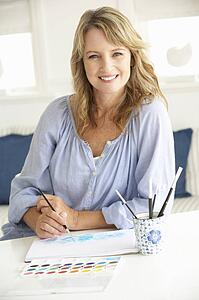 Mid age woman painting with watercolors