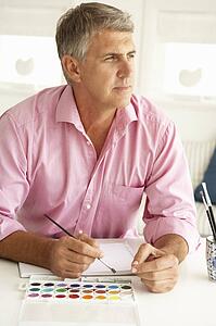 Mid age man painting with watercolors