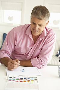Mid age man painting with watercolors