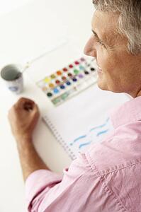 Mid age man painting with watercolors
