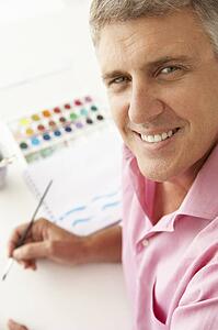 Mid age man painting with watercolors