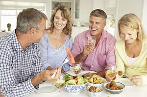 Mid age couples enjoying meal at home