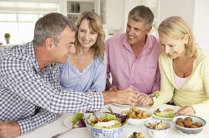 Mid age couples enjoying meal at home