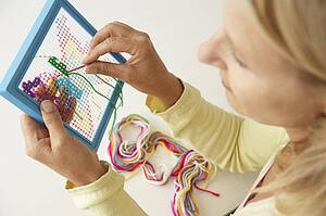 Mid age woman doing cross stitch