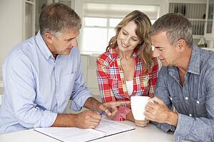Mid age couple with financial advisor at home