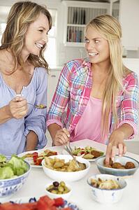 Mother and teenage daughter enjoying meal at home