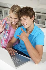 Teenage boy and girl using laptop