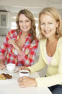 Mid age women chatting over coffee at home