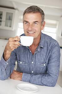 Mid age man with coffee at home